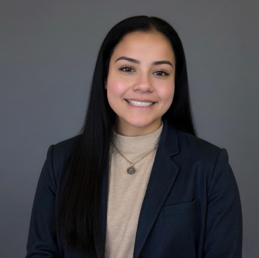 Co-Founder and Chief Executive Officer Gabriela Martinez The image is a headshot of Gabriela Martinez, co-founder and CEO of Tekcesta LLC. She is wearing a dark blue blazer over a tan shirt, casually dressed. Gabriela is a 23-year old Hispanic American woman. She has long brown hair and brown eyes. She is smilin
